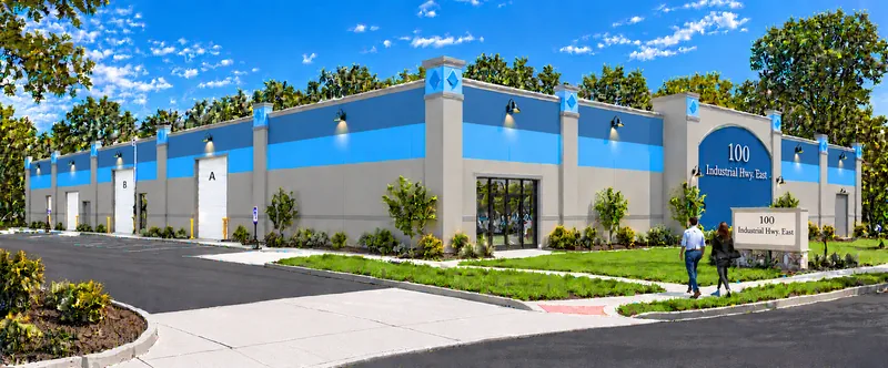 Color rendering of a single-story industrial building facade with blue accent bands and loading doors